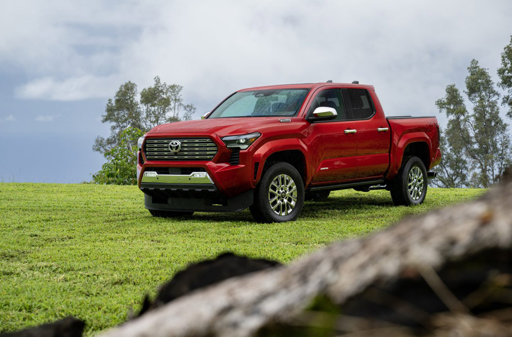 Red 2024 Toyota Tacoma parked on grass field